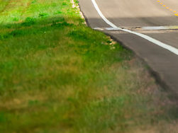 Combine harvesters moving from one field to another during the wheat harvest, along State Highway 27, north of Goodland, Kansas USA.